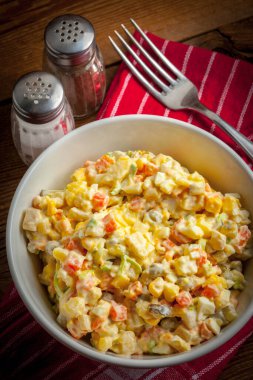 Patates, mısır, havuç, yumurta ve mayonezli salata. Sığ alan derinliği.