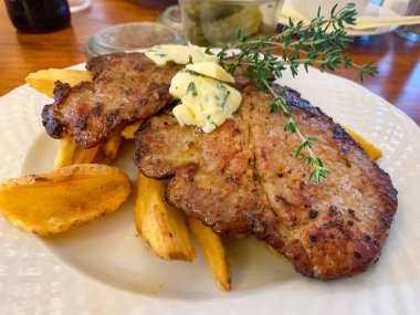 Boyun etinden kızarmış domuz bifteği ve kızarmış patates..