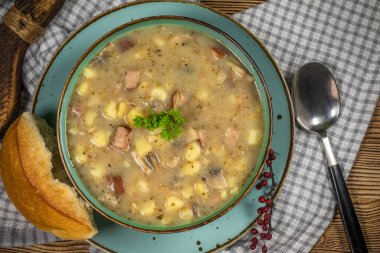 Sosis ve patatesli çavdar unundan yapılan ekşi çorba. Küçük alan derinliği.