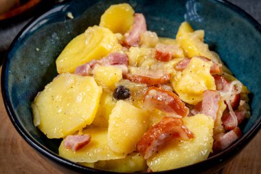 Geleneksel bir Polonya yemeği (pieczonki, prazonki, duszonki) - füme domuz pastırması, sosis ve soğanlı haşlanmış patates.