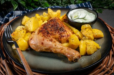 Akşam yemeğinde kızarmış patatesle servis edilen kahverengi derili iştah açıcı tavuk budu..