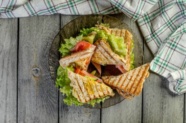 Panini sandviçle jambon, domates, marul bir plaka üzerinde. Üstten Görünüm.