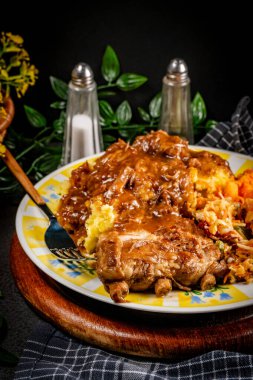 Patates püresi ve salatayla servis edilen acılı soslu domuz pirzolası. Sığ alan derinliği.