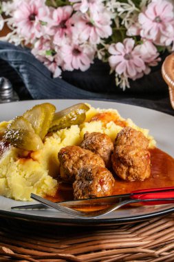 Ev yapımı hızlı yemek. Köfte, domuz eti ve üzerine kırmızı biber sosu sürülmüş patates püresi. Seçici odak.