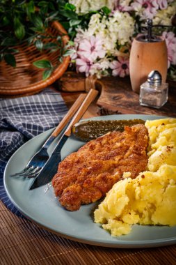 Patates ve salatalık turşusu ile servis edilen domuz pirzolası..