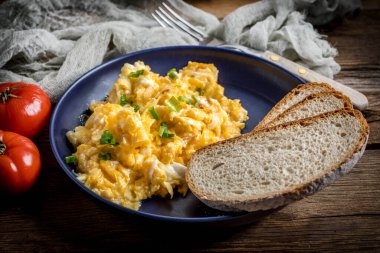 Sahanda yumurta soğan ve Frenk soğanı ile mavi tabakta ekmek ile servis.