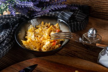 Bir dilim ekmeğin üzerinde çırpılmış yumurta, kırmızı biber, bitki ve domatesle kızartılmış..