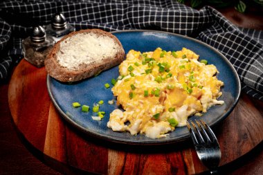 Sahanda yumurta soğan ve Frenk soğanı ile mavi tabakta ekmek ile servis.