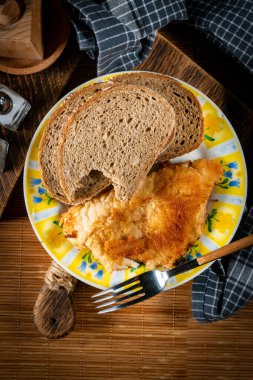 Ekmek dilimleriyle servis edilen kızarmış morina filetosu. Sığ alan derinliği.