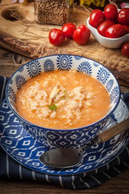 Mavi bir kase pilav ile taze domates çorbası.