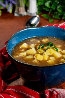 Mavi kasede patates ve mantarlı ekşi çorba..