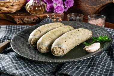 Bir tabakta üç pişmiş beyaz sosis. Seçici odak.