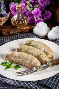 Bir tabakta üç pişmiş beyaz sosis. Seçici odak.