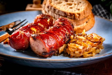 Tabakta soğanlı kızarmış sosis. Sığ alan derinliği.