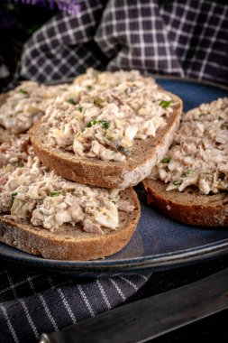 Tahta bir tahtanın üzerinde ton balıklı sandviç ve yumurta. Sığ alan derinliği. 