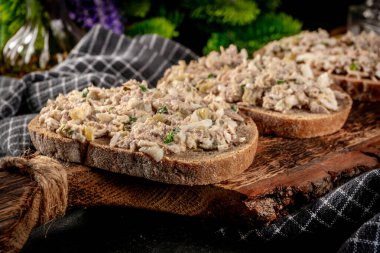 Tahta bir tahtanın üzerinde ton balıklı sandviç ve yumurta. Sığ alan derinliği. 