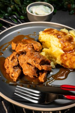 Sos ve patates püresiyle servis edilen haşlanmış hindi eti. Sığ alan derinliği.