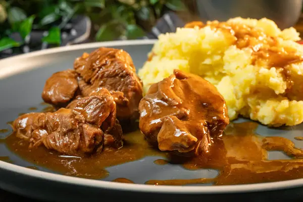 Sos ve patates püresiyle servis edilen haşlanmış hindi eti. Sığ alan derinliği.