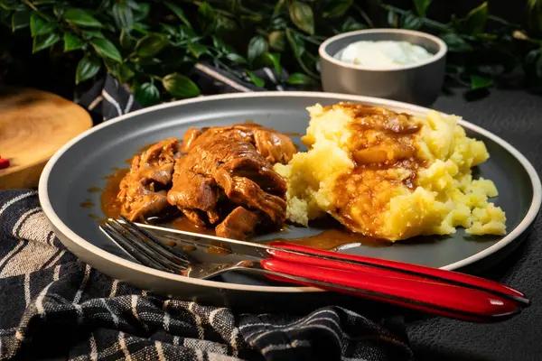 Sos ve patates püresiyle servis edilen haşlanmış hindi eti. Sığ alan derinliği.