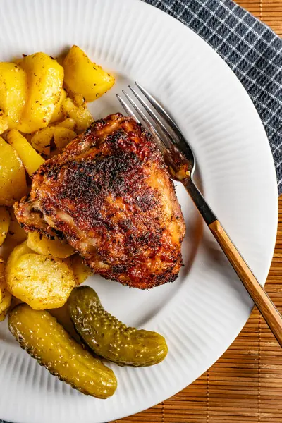 Akşam yemeğinde patates ve salatalık turşusuyla servis edilen kaşarlı kızarmış tavuk budu..