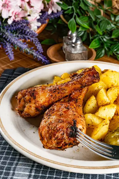 Fırında tavuk budu ve patates. Sığ alan derinliği. 