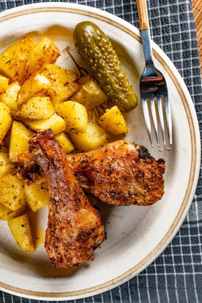 Fırında tavuk budu ve patates. Sığ alan derinliği. 