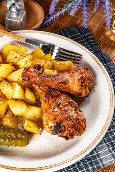 Fırında tavuk budu ve patates. Sığ alan derinliği. 