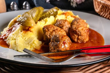 Ev yapımı hızlı yemek. Köfte, domuz eti ve üzerine kırmızı biber sosu sürülmüş patates püresi. Seçici odak.