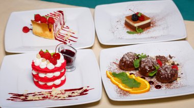 Sokaktaki havuzun arka planında tabakta dört tatlı tatlının kompozisyonu. Ahududulu cheesecake, kirazlı millefeuille, çikolatalı profiterol, böğürtlenli puding
