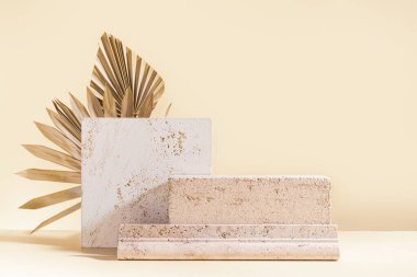 Abstract modern still life. Natural materials. Composition of palm leaves, travertine and concrete blocks.