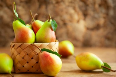 Sepeti ahşap masa üzerinde taze olgun armut. Organik meyve, kopya alanı ile sağlıklı beslenme kavramı.