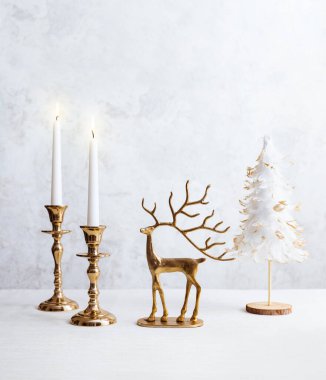 Yanan mumlarla dolu rahat bir hayat, geyik figürü ve pastel ışıklı arka planda noel ağacı. Evin Noel kompozisyon dekorasyonu.