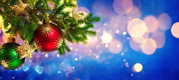 クリスマスの装飾品や新年の装飾 クリスマスボール お祝いのボケの背景にモミの枝の金の星 冬休みグリーティングカード ストック画像