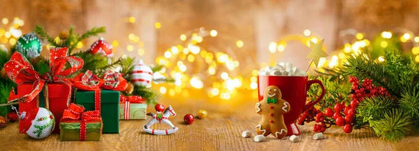 クリスマスや新年はまだギフトボックス クリスマストリートメント 火の木 冬の果実と木のテーブルでお祝いの装飾で生きています バナー ロイヤリティフリーのストック画像