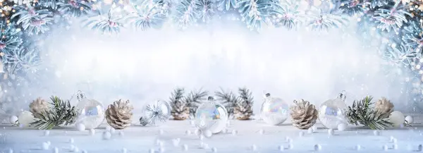 Christmas banner with snowy pine cones, transparent Christmas balls and  fir branches on light background. Winter or Christmas festive concept.