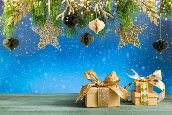 クリスマスや新年のお祝いのコンポジション 木のテーブルの繊維の枝 金のクリスマスの装飾およびギフト用の箱 ロイヤリティフリーのストック画像