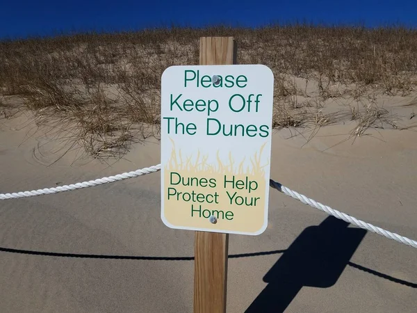 stock image please keep off the dunes sign with sand and plants at the beach