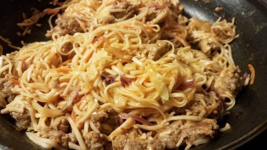 sausage meat and spaghetti pasta in a frying pan