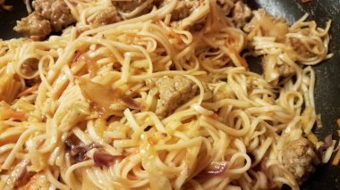 sausage meat and spaghetti pasta in a frying pan