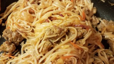 sausage meat and spaghetti pasta in a frying pan