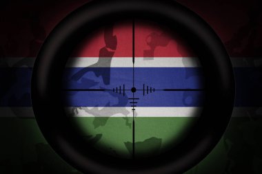 sniper scope aimed at national flag of gambia on the khaki texture background. military concept. 3d illustration clipart