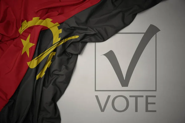 Махаючи Барвистим Національним Прапором Анголи Сірому Фоні Текстовим Голосуванням Концепція — стокове фото