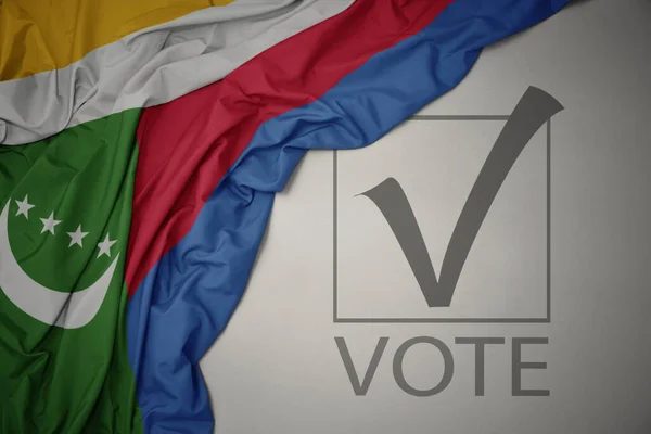 Κυματίζει Πολύχρωμη Εθνική Σημαία Των Comoros Γκρι Φόντο Ψηφοφορία Κειμένου — Φωτογραφία Αρχείου