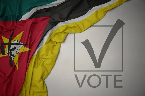 Махаючи Барвистим Національним Прапором Мозамбіку Сірому Фоні Текстовим Голосуванням Концепція — стокове фото