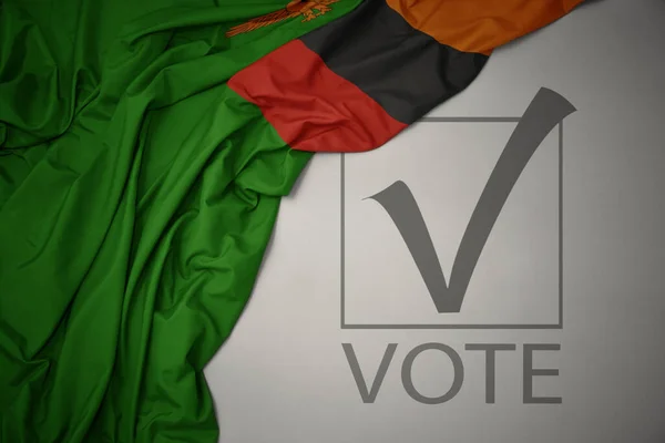 Machanie Kolorową Flagą Narodową Zambii Szarym Tle Głosowaniem Tekstowym Koncepcja — Zdjęcie stockowe