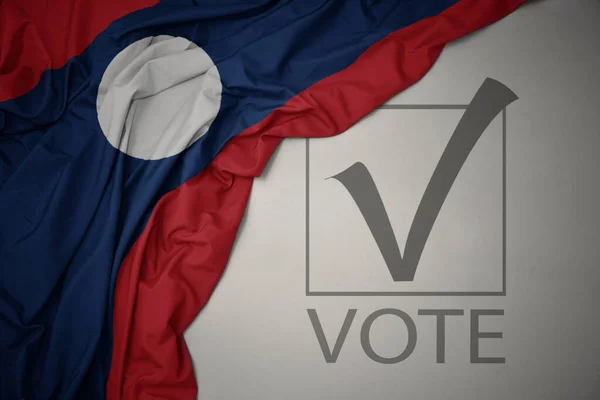 Színes Nemzeti Laoszzászlót Lobogtatva Szürke Háttérrel Szöveges Szavazással Választási Koncepció — Stock Fotó