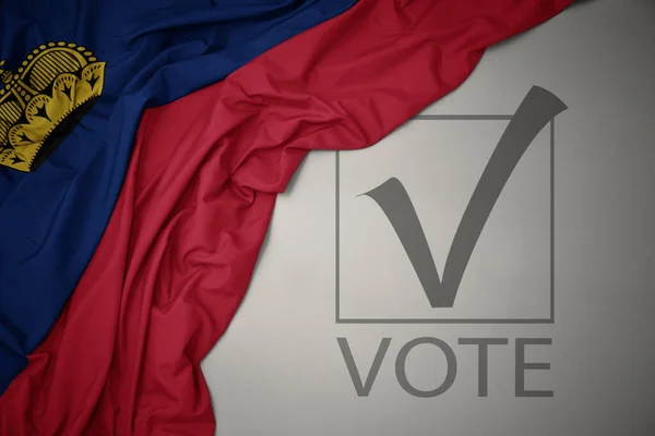 Machanie Kolorową Flagą Narodową Liechtensteina Szarym Tle Głosowaniem Tekstowym Koncepcja — Zdjęcie stockowe