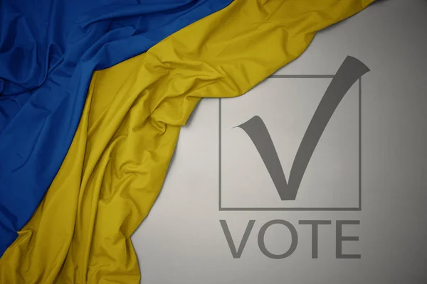 Machanie Kolorową Flagą Narodową Ukrainy Szarym Tle Głosowaniem Tekstowym Koncepcja — Zdjęcie stockowe