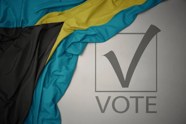 Machanie Kolorową Flagą Narodową Bahamów Szarym Tle Głosowaniem Tekstowym Koncepcja — Zdjęcie stockowe