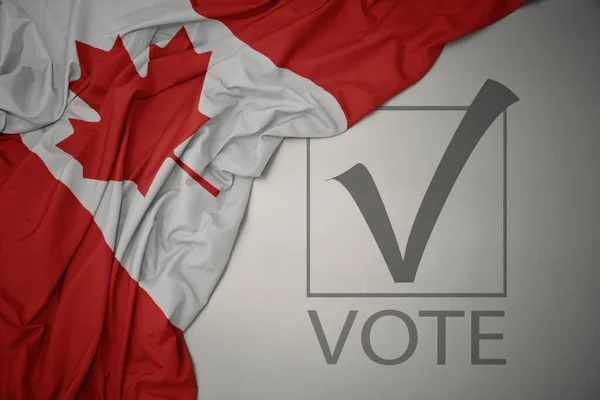 Machanie Kolorową Flagą Narodową Kanady Szarym Tle Głosowaniem Tekstowym Koncepcja — Zdjęcie stockowe